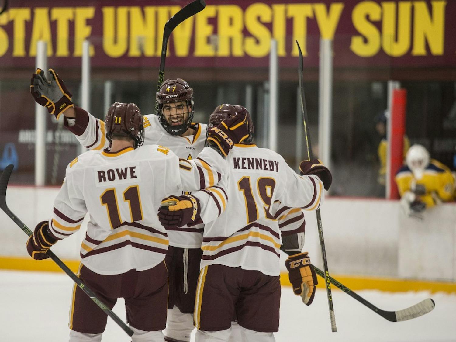 Left wing Jack Rowe, left, and center Matt Kennedy, right, celebrate a goal by defender Nicholas Gushue, center, during a game at the Oceanside Ice Arena in Tempe, Ariz. The Sun Devils lead Southern New Hampshire 4-1 after the first period. 
