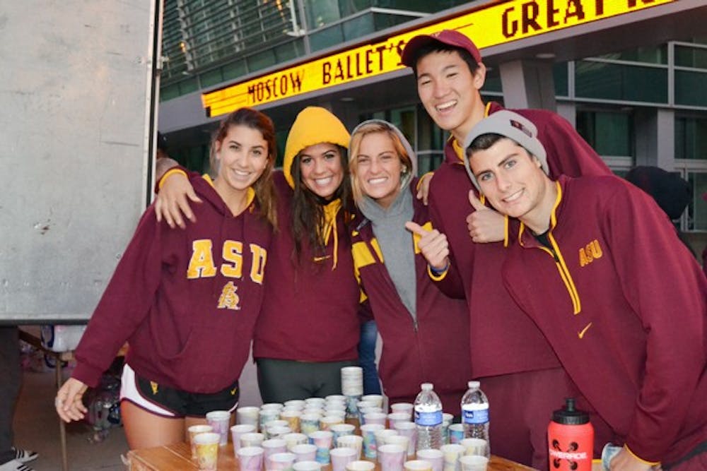 CAN’T MISS: A group of ASU student-athletes pose at a water station at the Susan G. Komen Race for the Cure on Sunday. ASU athletics has made it a tradition to have athletes help out at the event every year. (Photo courtesy of Rebecca Edelman)