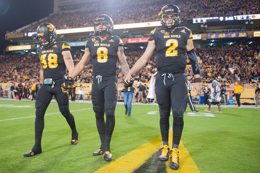 Redshirt senior defensive back Jordan Simone (38), Senior wide receiver D.J. Foster (8) and Redshirt senior quarter back Mike Bercovici (2) take the field for the coin toss before a game against Colorado on Saturday, Oct. 10, 2015, at Sun Devil Stadium in Tempe.