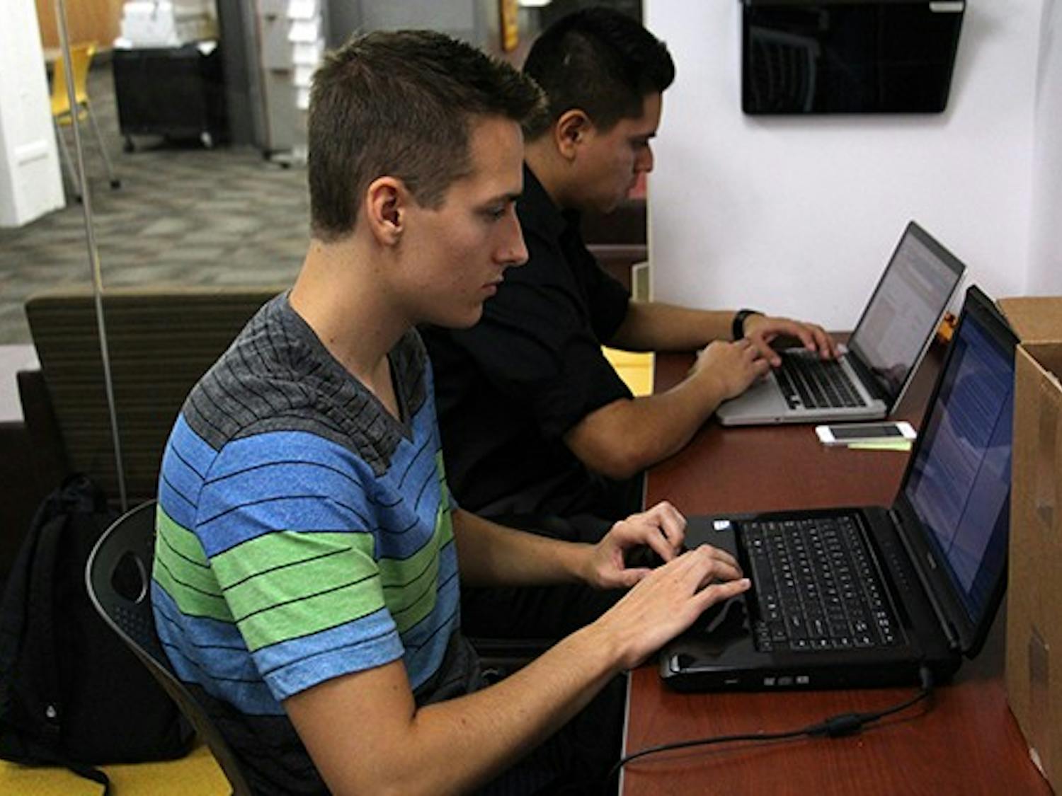 Public service and public policy freshman Thomas Prior and public service and public policy junior Eduardo Alonso work during their office hours as interns for the USGD in the Downtown campus's Post Office. (Photo by Tynin Fries) 