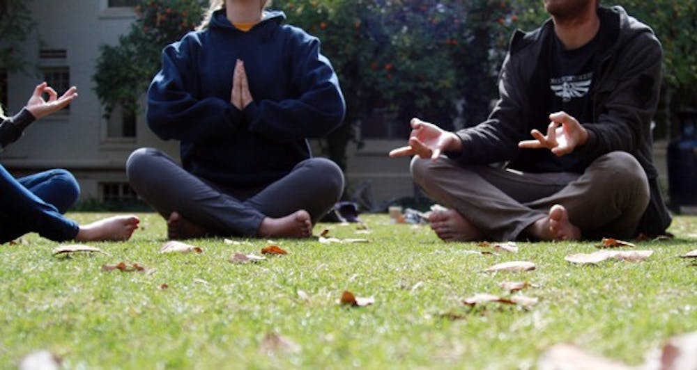 A few ASU students meditate in the secret garden to relieve themselves of stress. Starting Thursday, Quiet Your Mind and Focus meditation sessions will take place for an hour every week in the Discovery Hall to help students relieve stress in their daily lives. (Photo by Shelby Bernstein)