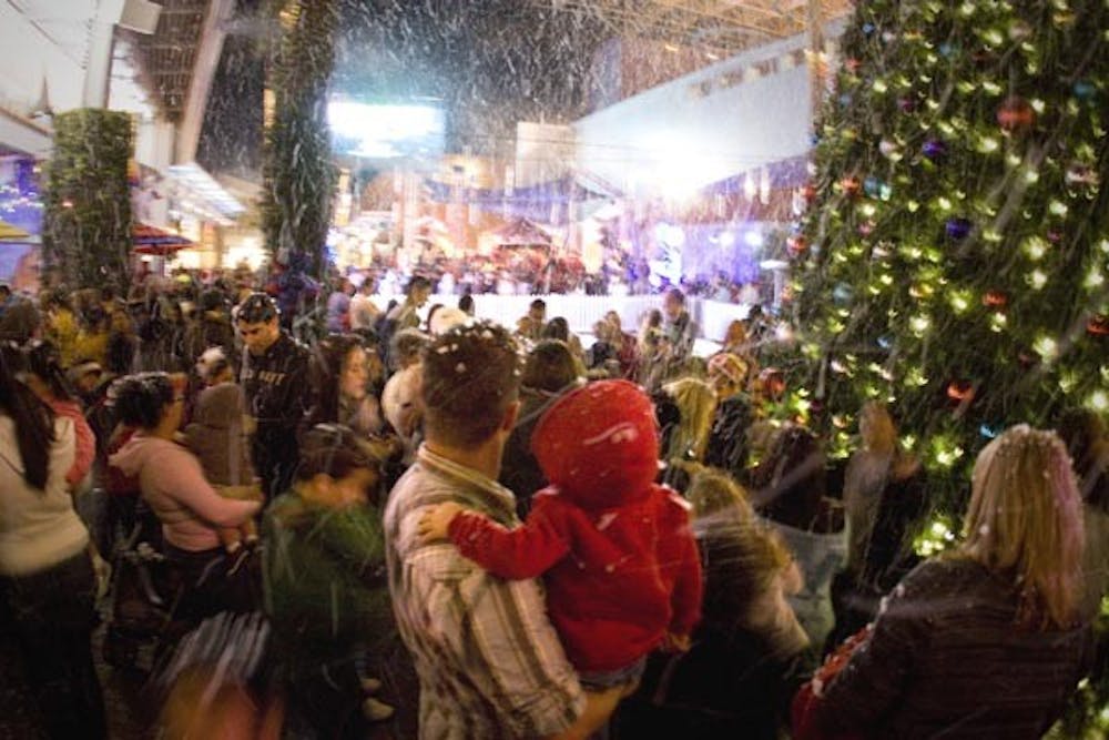 LET IT SNOW: Snow blowers covered Tempe Marketplace in white on Wednesday night, kicking off the winter holiday season. (Photo by Annie Wechter)