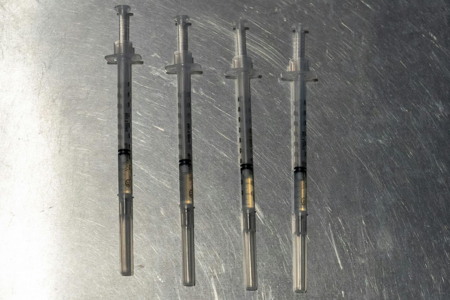 Se muestran cuatro jeringas que contienen la vacuna Pfizer
