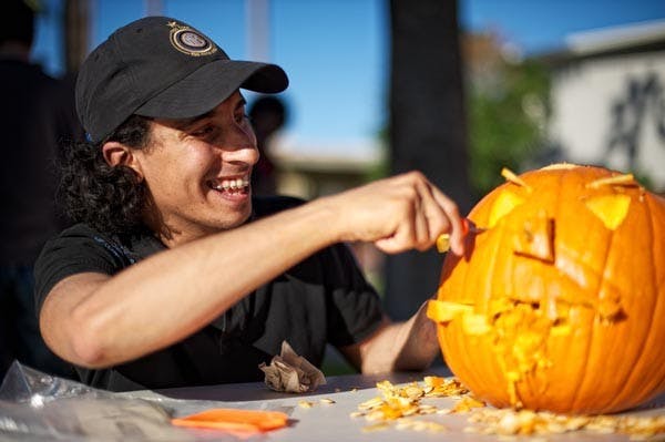 FEELS LIKE FALL: Mohammed Al-Bassan, a graduate business student from Saudi Arabia, puts the finishing touches on his Jack-o-Lantern during the AECP's (American English and Culture Program) annual pumpkin carving day on Palm Walk Tuesday afternoon. (Photo by Michael Arellano)