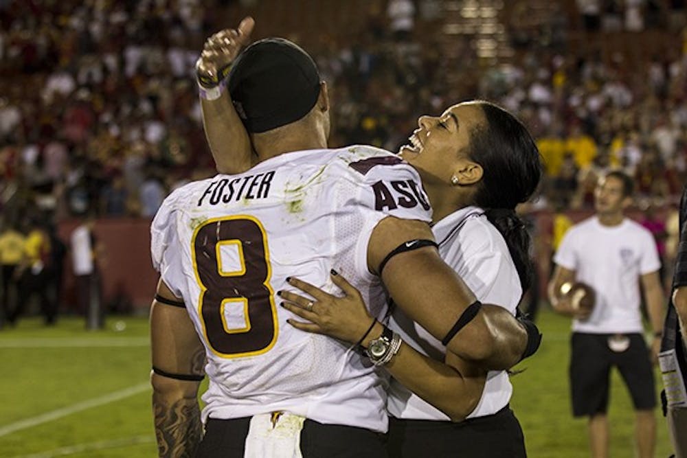 Junior running back D.J. Foster celebrates with one of his fans after winning against USC on Oct. 4, 2014. ASU won against USC 38-34. (Photo by Alexis Macklin)