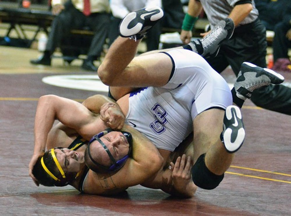 Undefeated: ASU senior Anthony Robles tilts Cal Poly redshirt freshman Britain Longmire during Robles’ 15-0 technical fall victory. The win improved Robles’ record to 24-0, but the Sun Devils ultimately fell to the Mustangs, 40-11. (Photo by Rosie Gochnour)