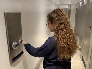 ASU Junior Tina Giuliano uses the menstrual products dispenser in the Memorial Union on the Tempe campus in Tempe, Arizona on Thursday, Aug. 29, 2019.  