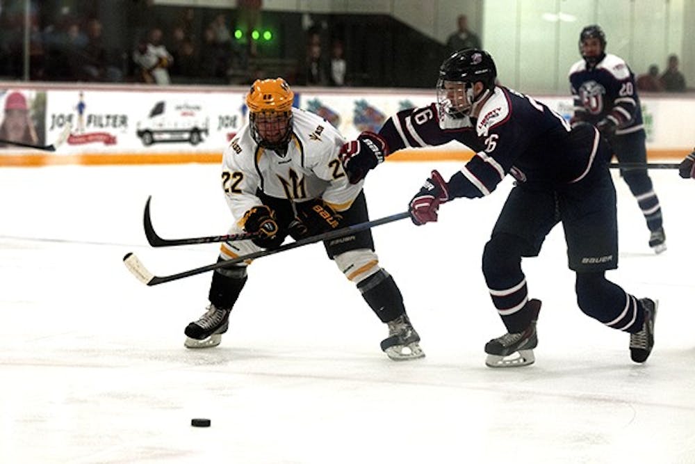 Forward Ryan Belonger vies for the puck with a Liberty defender. ASU had a close match with Liberty University at Oceanside Arena on Thursday, Oct. 23, 2014. ASU won 6-4. (Photo by Mario Mendez)