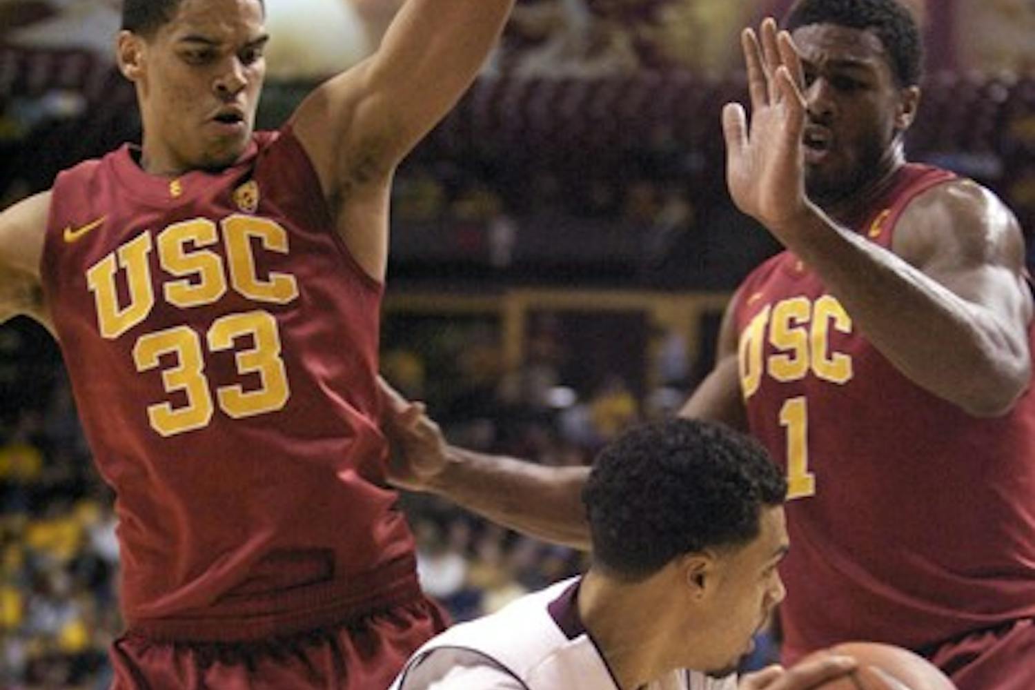 Stuffed: ASU sophomore guard Trent Lockett attempts to drive around USC freshman forward Garrett Jackson (33) and redshirt senior forward Alex Stepheson during the Sun Devils’ 63-61 loss to the Trojans in Tempe on Thursday night. (Photo by Scott Stuk)