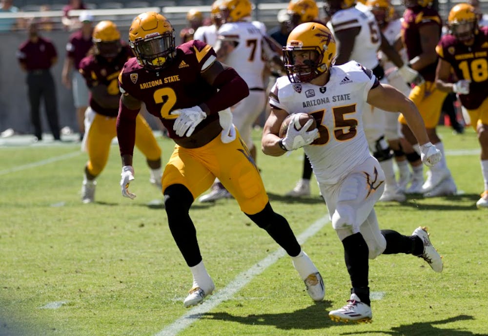 ASU senior Jacom Brimhall (22, white) runs the football as redshirt junior linebacker Christian Sam (2, maroon) chases him down to try and make the tackle during the annual Spring Football Game in Sun Devil Stadium in Tempe, Arizona on Saturday, April 17, 2017.