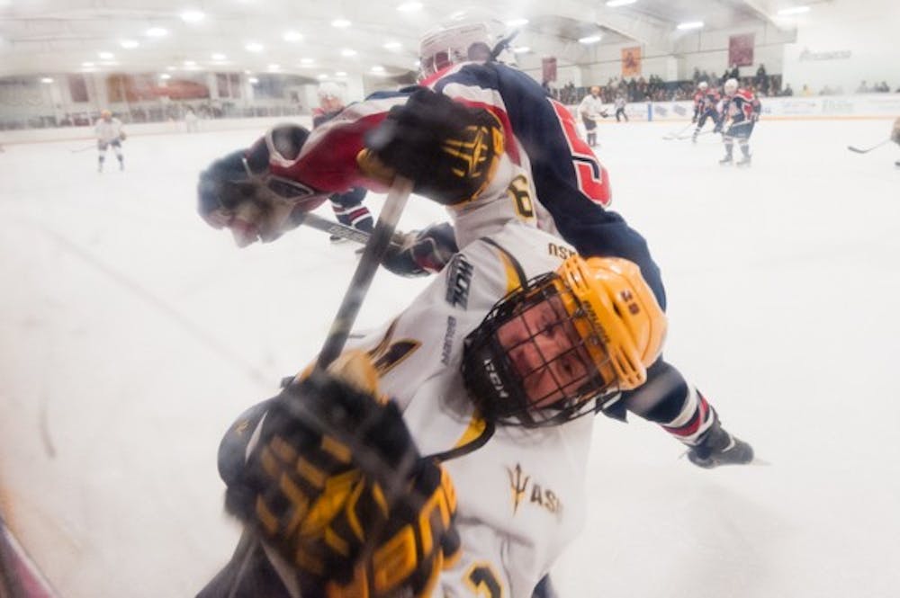 Junior forward Kory Chisholm is fouled by Arizona on, Saturday, Jan. 31, 2015, at Oceanside Ice Arena in Tempe. The Sun Devils defeated the Wildcats 7-2. (Ben Moffat/The State Press)