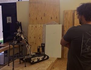 Joshua Kosar, president of robotics club Rossum Rumblers, watches as his robot attempts to pick up an object at the Night of the Open Door Event on Friday, Feb. 17, 2017.