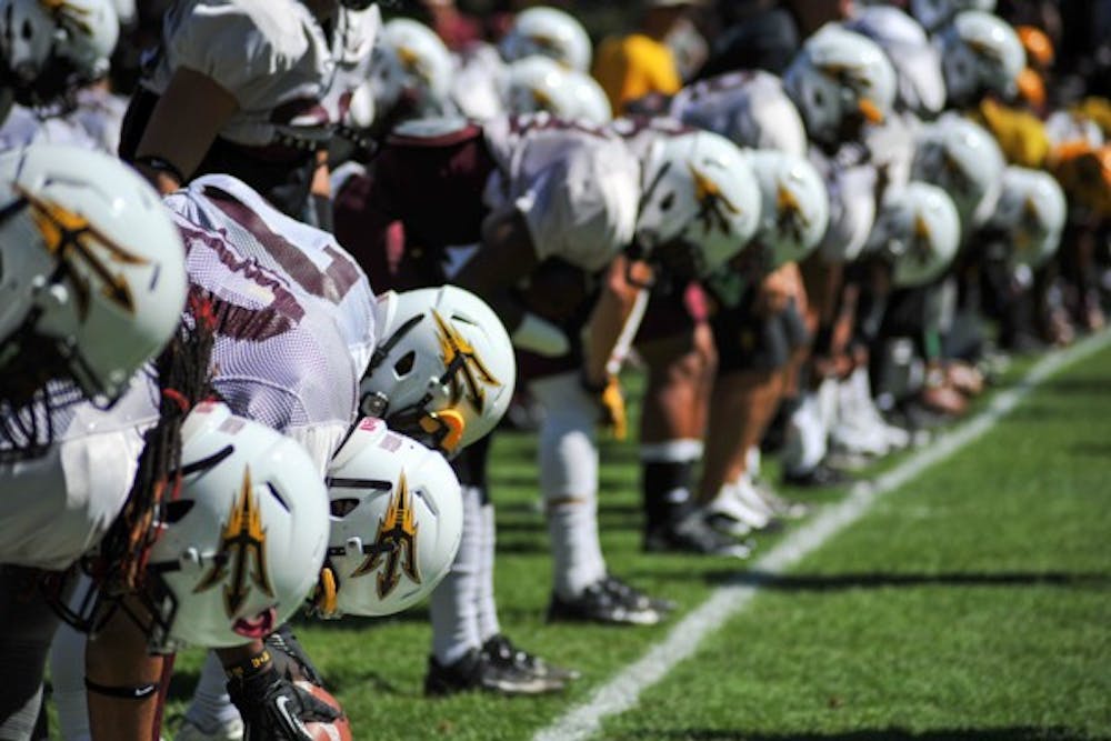 ASU football players stretch before a scrimmage at Camp Tontozona on Aug. 16. (Photo by Andrew Ybanez)