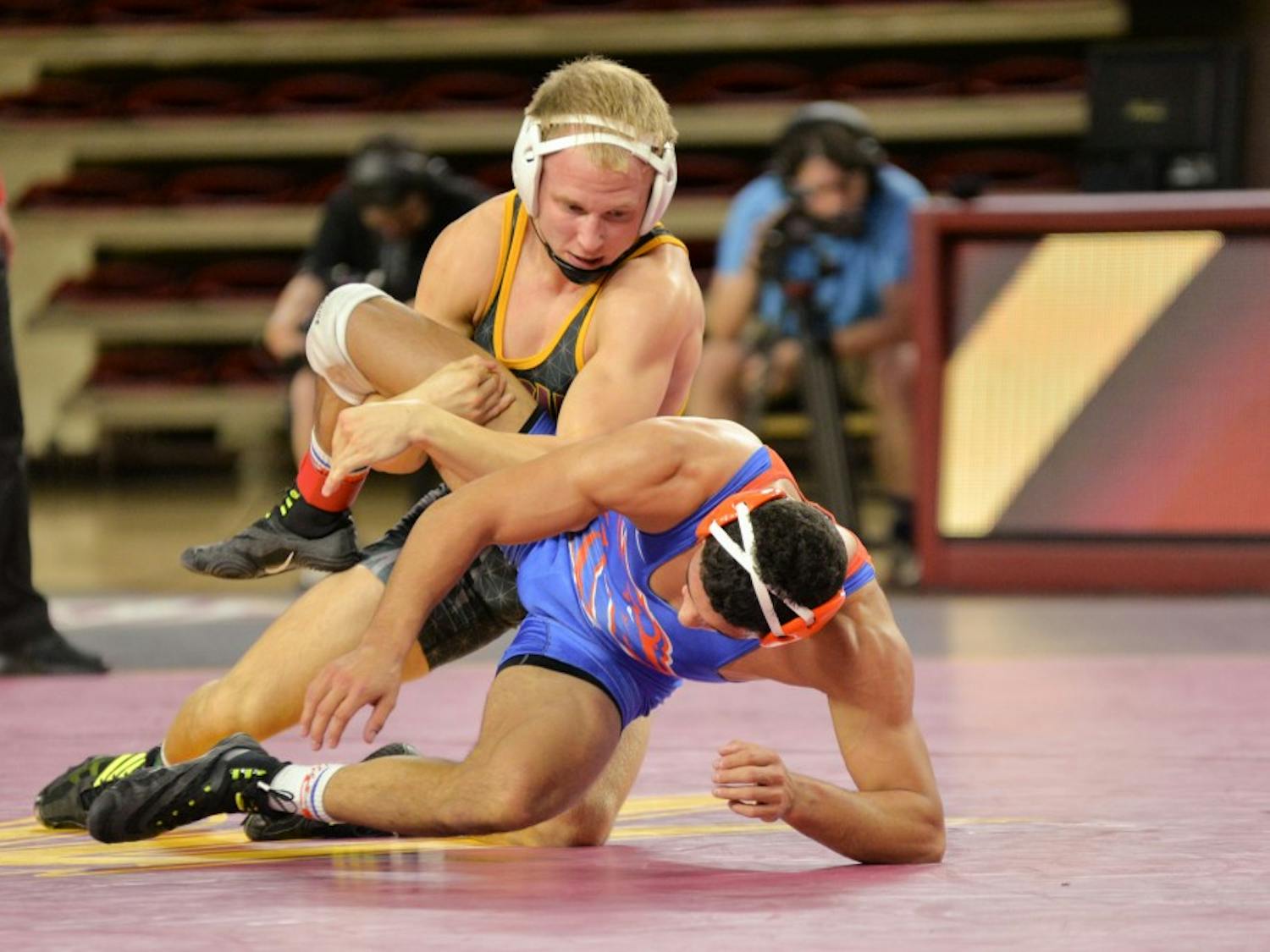 Sun Devil senior Matt Kraus and Geordan Martinez from Boise State take it to the mat during the final match between the two schools on Sunday, Nov. 21, at the Wells Fargo Arena in Tempe, AZ.