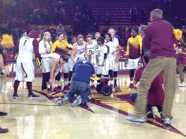 The ASU women's basketball team rings the victory bell after defeating WSU on Monday, Jan. 5, 2015, in Tempe. (Logan Newman/The State Press)