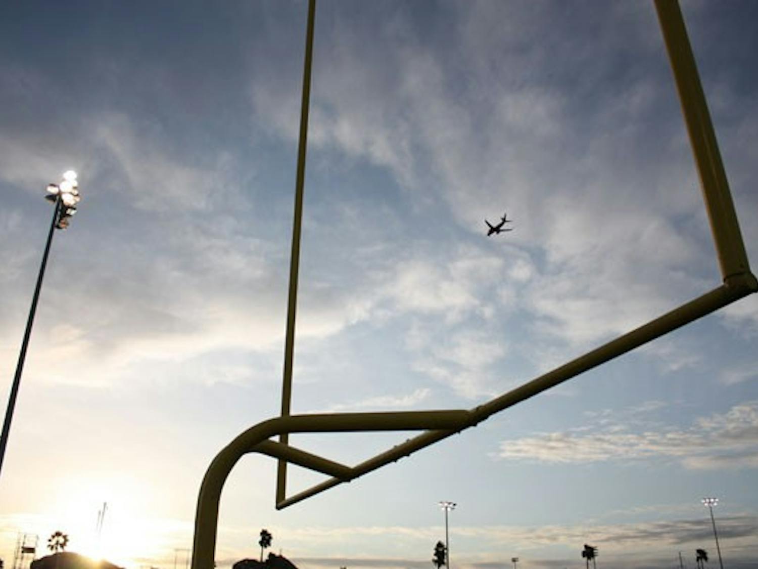 HIGH FLYING: At sunset, a plane flies "through" the field goal on the football practice field during practice last week. (Photo by Kyle Thompson)