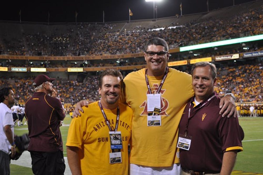 The creators of the pitchfork hand sign, Joe Cuff (left), Mark Carlino and Adam Driggs pose on the field during the ASU football game against NAU on Aug. 30.
(Photo courtesy of Adam Driggs)