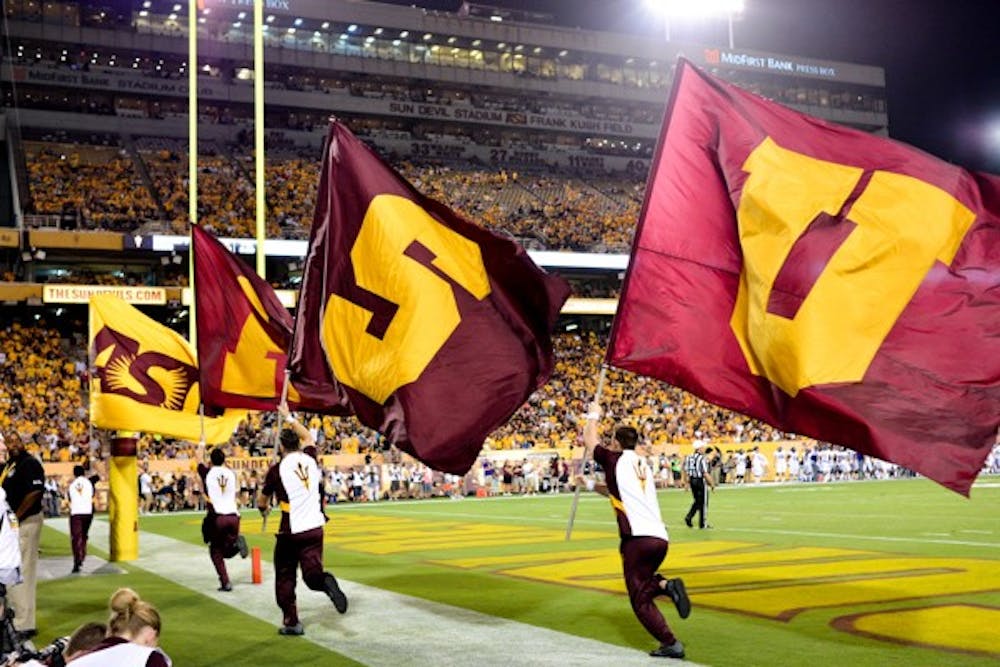 The ASU flags are carried across the end zone after a Sun Devil touchdown against Weber State on Aug. 28. (Photo by Andrew Ybanez)