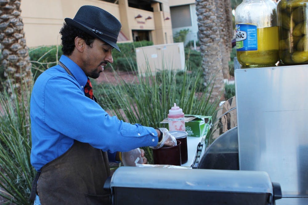 Frenchy prepares his famous Caribbean dog with tomato salsa and shredded carrot sauce. His slogan is "make any dog a Caribbean dog," and his signature hot sauces have a heavy creole influence. (Photo by Dominic Valente)