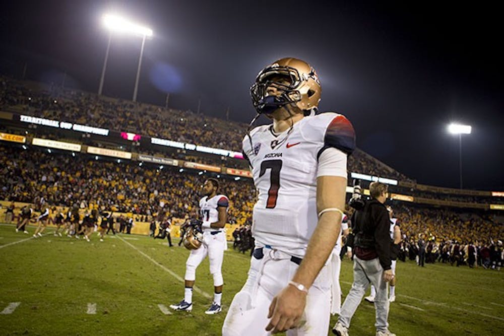 Senior quarterback D.J. Benker exits the field after UA's defeat to ASU. The Sun Devils defeated UA 58-21 and clinched a home field advantage for the Pac-12 chcampionship. (Photo by Dominic Valente)