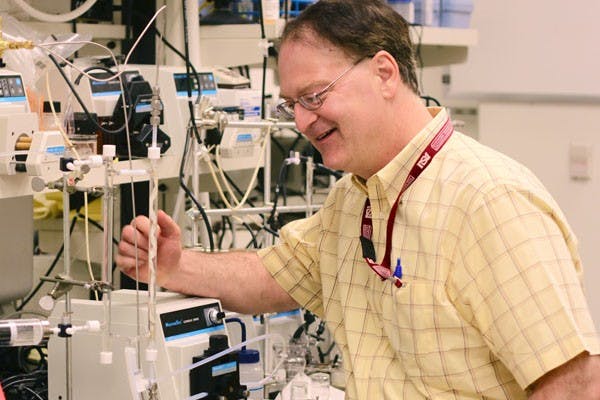 GREEN MACHINE: Dr. Bruce Rittmann, director of the Swette Center for Environmental Biotechnology at the Biodesign Institute, works with his laboratory scale version of the membrane biofilm reactor last week. Rittman will be traveling to Washington, D.C., to receive the Environmental Engineering Excellence Award from the American Academy of Environmental Engineers.  (Photo by Rosie Gochnour)