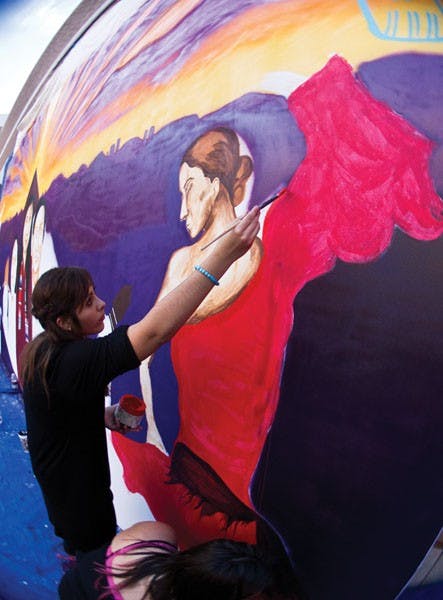 Freshman sociology major Carolina Hernandez and interdisciplinary art and performance senior Shiloh Ashley help paint the Calle 16 Mural Project in 2012.  The mural was unveiled at the West campus along with the closing ceremonies for the celebration of Hispanic Heritage Month. (Photo by Vince Dwyer)