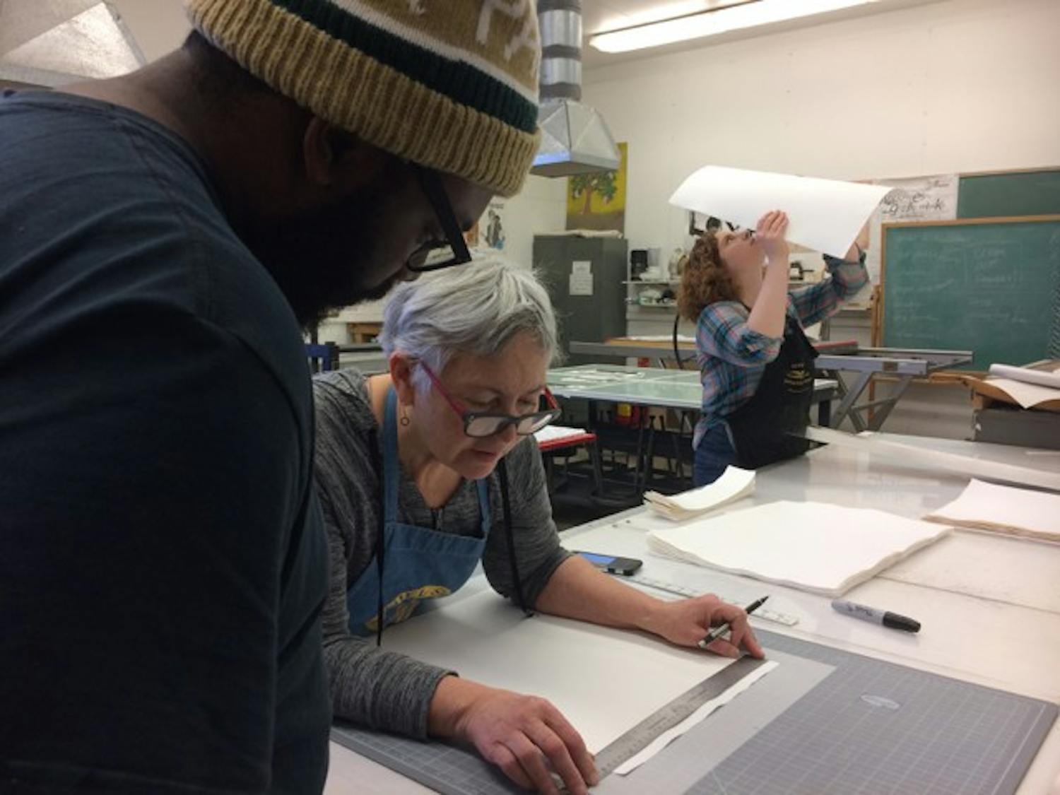 Jonathan Wright (left) works with visiting artist Brenda Mallory to create a unique work of art inspired by Mallory's Native American heritage. 