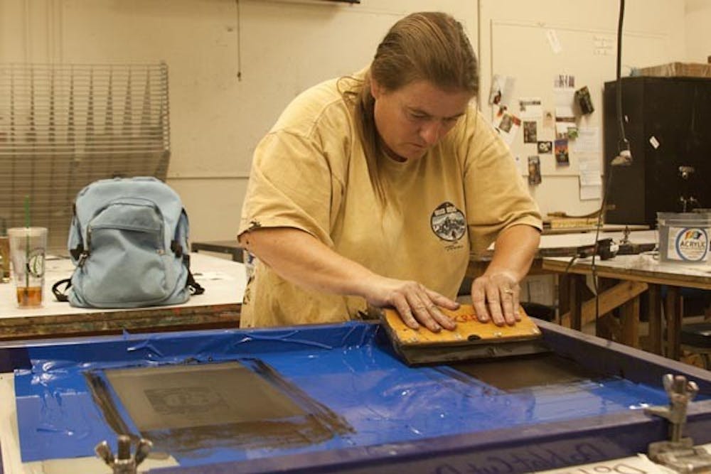 WORKING LATE: Photography graduate student Jane Lindsay takes on printmaking, finishing a project Sunday. (Photo by Annie Wechter)