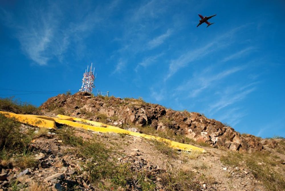 An airplane flies over the "A" on top my Hayden Butte near the Tempe Campus on a bright September afternoon. (Photo by Kurtis Semph)