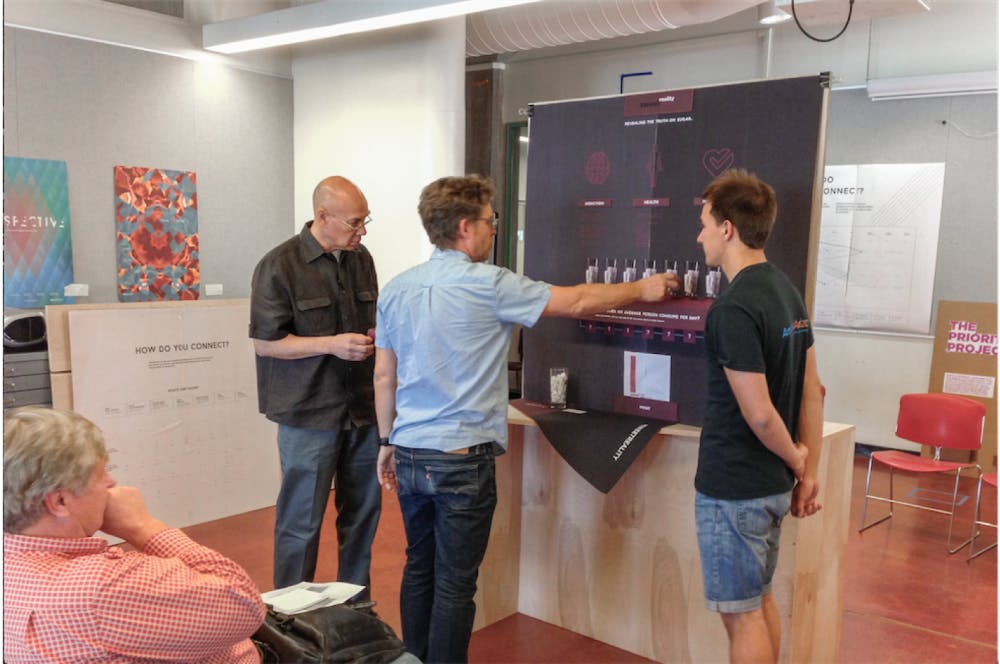 Pictured above: Professors Alfred Sanft (left) and Eric Montgomery (right) are critiquing Maxim Golberg’s prototype of his exhibit which aims to inform people about overconsumption of sugar and&nbsp;its harmful effects.