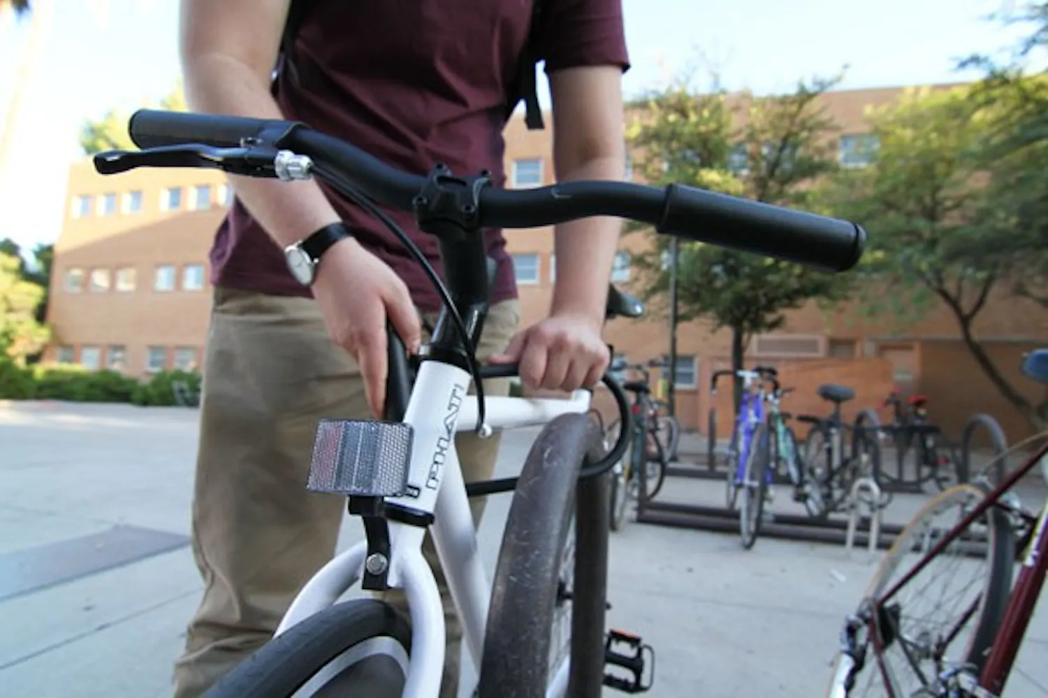 Junior mechanical engineering student Matt Carrion locks up his bike before entering Hayden Library on Thursday. (Photo by Sam Rosenbaum)