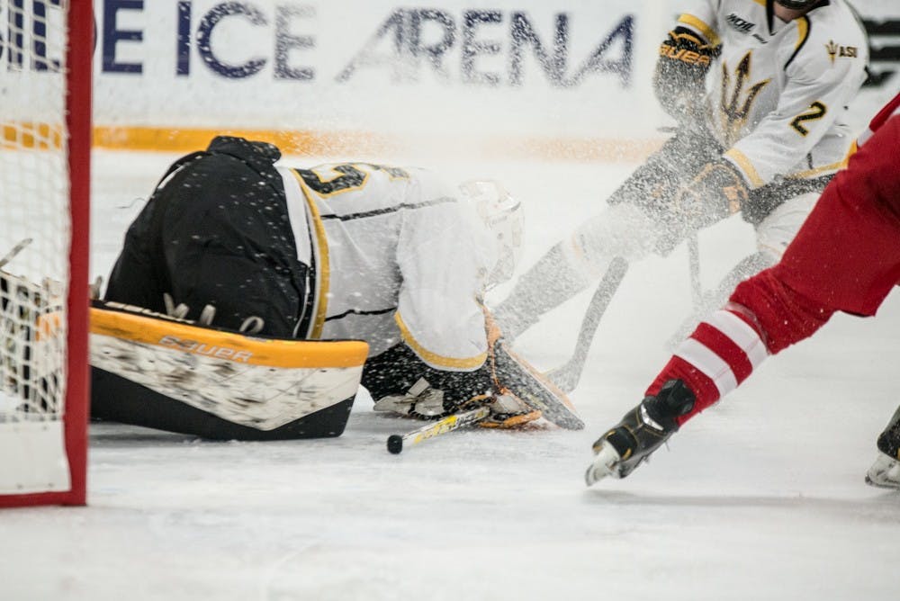 Sophomore goalie Robert Levin makes a dramatic stop as the ice flies on Jan. 22, 2015, at Oceanside Arena in Tempe. (J. Bauer-Leffler/The State Press)