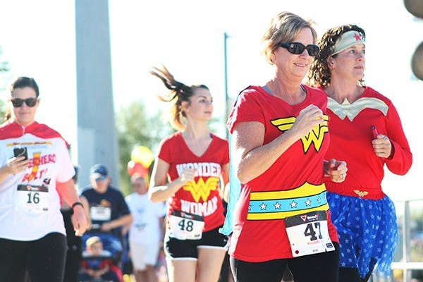 Polly and Kailey Grapes are among a pack of Wonder Women at the Singleton Moms Superhero Bolt 5k on Saturday, Nov. 8, 2014. The 5k run was to raise money and awareness for single parents with cancer. (Photo by Sawyer Hardebeck)
