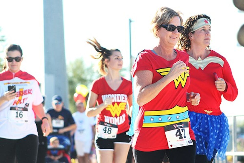 Polly and Kailey Grapes are among a pack of Wonder Women at the Singleton Moms Superhero Bolt 5k on Saturday, Nov. 8, 2014. The 5k run was to raise money and awareness for single parents with cancer. (Photo by Sawyer Hardebeck)