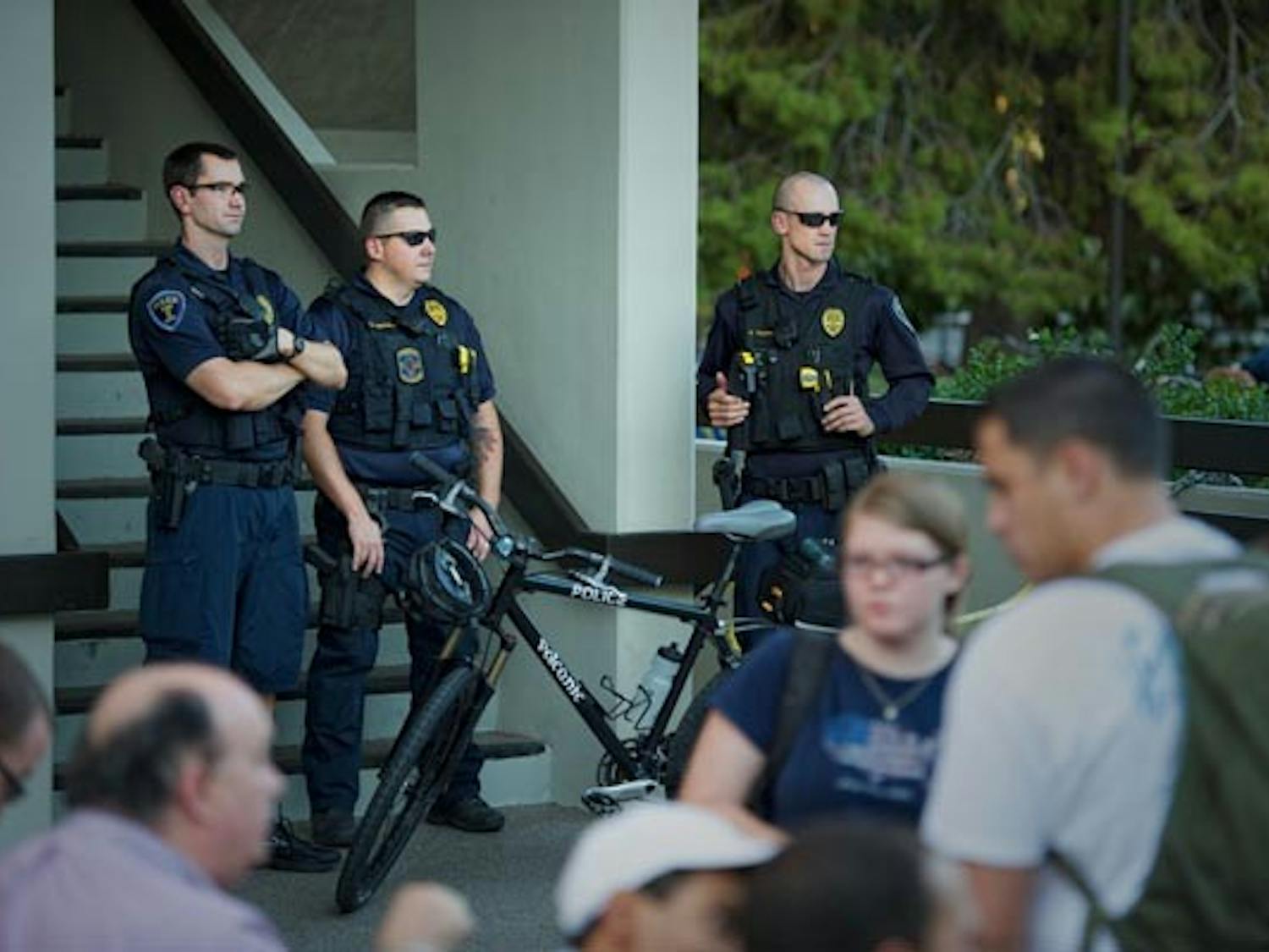 FALSE ALARM: Tempe police watch oer the crowd gathered in front of the BAC building, during the lock-down of the W.P. Carey schools after a reported bomb threat. (Photo by Michael Arellano)