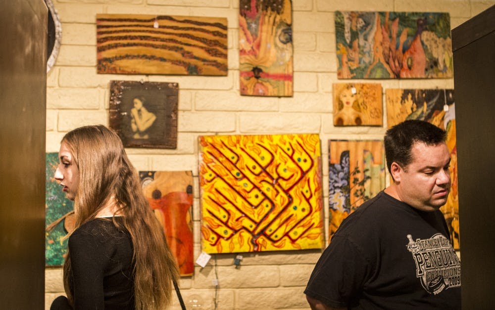 Visitors look around the My Little Phobia Art Show at the Firehouse Art Gallery in downtown Phoenix on Friday, Oct. 9, 2015. 