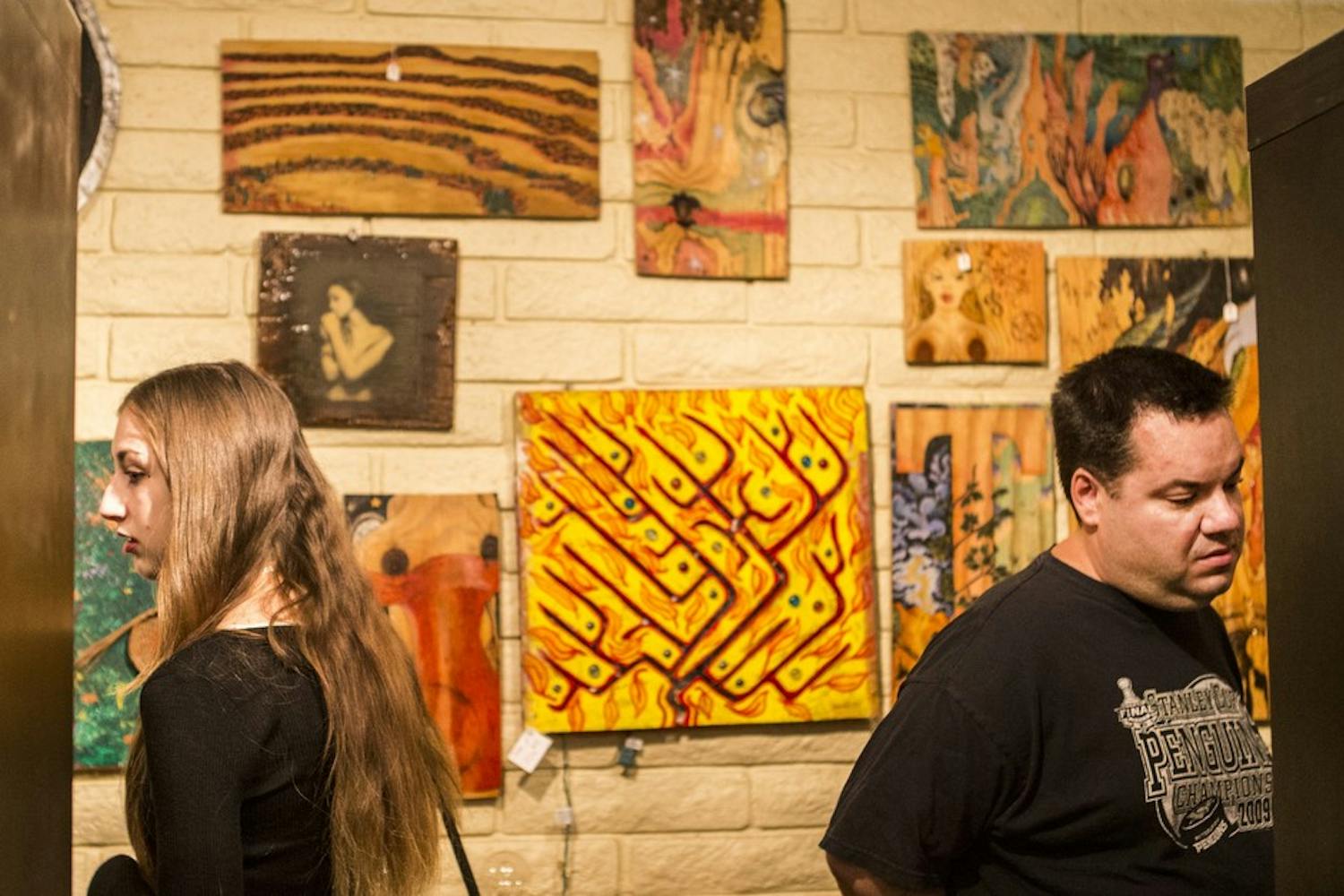 Visitors look around the My Little Phobia Art Show at the Firehouse Art Gallery in downtown Phoenix on Friday, Oct. 9, 2015. 