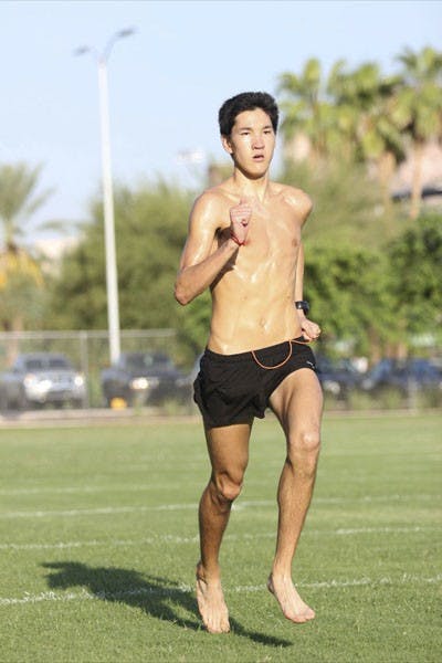 Redshirt freshman Daniel Wong runs across a field during an ASU men’s cross country practice on Wednesday. (Photo by Kyle Newman)