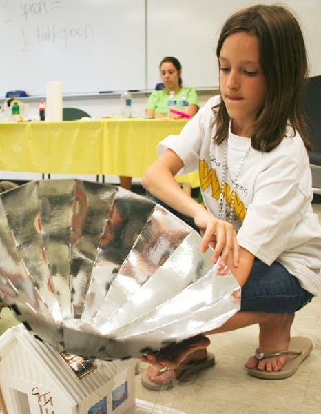 ELEMENTARY SCHOOL ENGINEER: Fifth-grader Madison Kuhler from Scottsdale puts the finishing touches on a model solar home during the Wow! engineering event on the Tempe campus Saturday. 