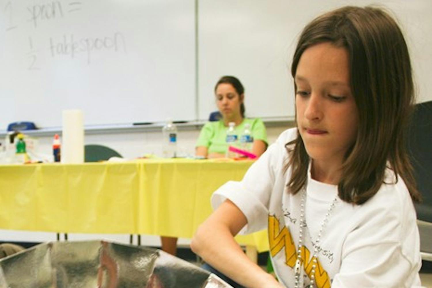 ELEMENTARY SCHOOL ENGINEER: Fifth-grader Madison Kuhler from Scottsdale puts the finishing touches on a model solar home during the Wow! engineering event on the Tempe campus Saturday.