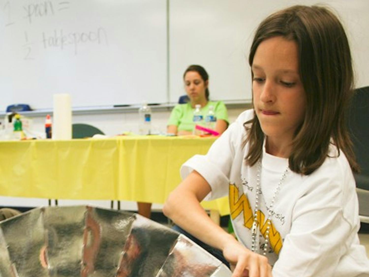 ELEMENTARY SCHOOL ENGINEER: Fifth-grader Madison Kuhler from Scottsdale puts the finishing touches on a model solar home during the Wow! engineering event on the Tempe campus Saturday. 