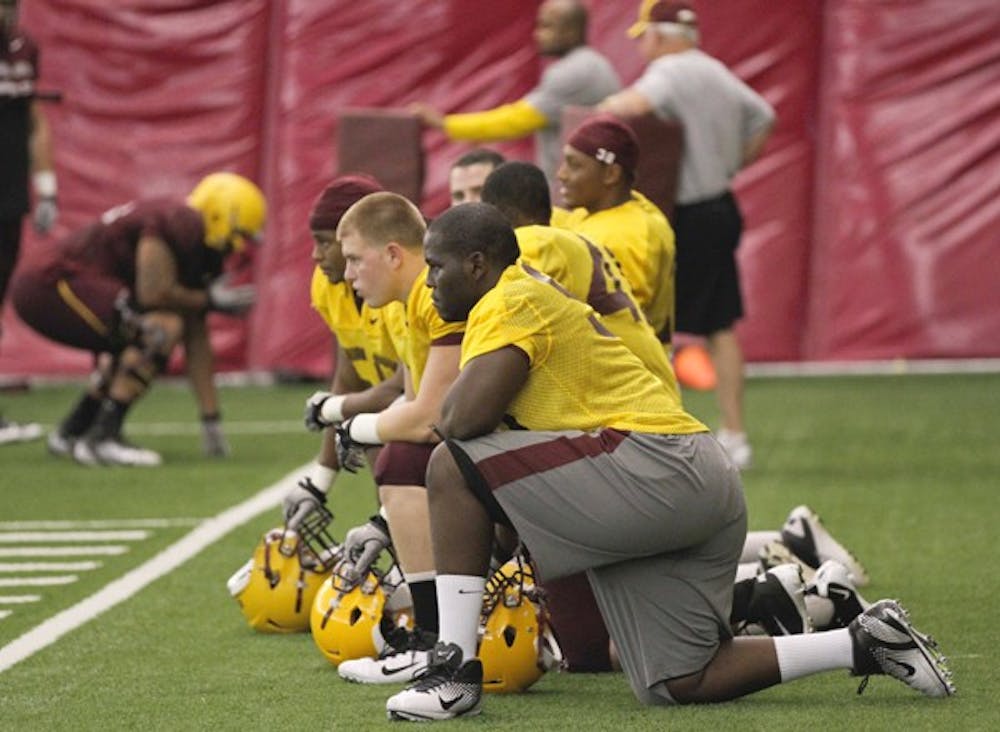 LOOKING AHEAD: Members of the ASU football scout team kneel on the field during Monday’s practice. Head coach Dennis Erickson credits his scout team for providing valuable practice prior to games. (Photo by Lisa Bartoli)