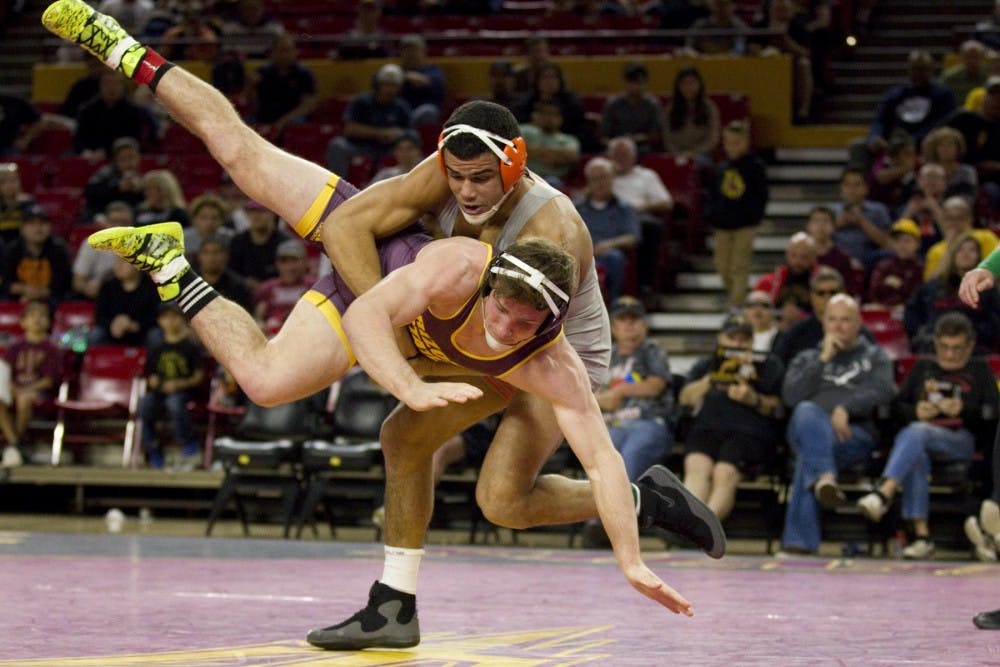 ASU's Jacen Petersen (184) gets driven towards the mat by Illinois' number twelve Emery Parker during the wrestling meet versus number 13 University of Illinois Fighting Illini in Wells Fargo Arena in Tempe, Arizona on Sunday, Jan. 29, 2017. ASU lost the meet overall 26-9. (Josh Orcutt/State Press)