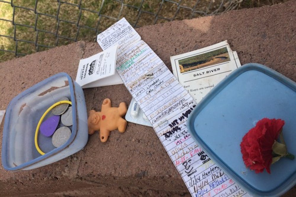 The contents of a geocache are displayed near the north shore of Tempe Town Lake on Sunday, Jan. 11, 2015, in Tempe. The owner of the geocache created it in memory of their dog, Elija Jane. (Rachel Andrews/The State Press)