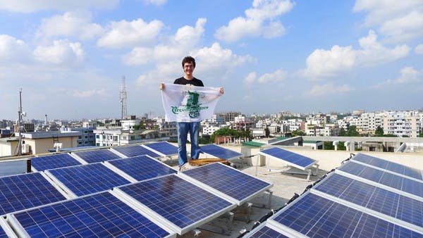 FOREIGN ADVENTURES: While visiting Dhaka, Bangladesh, Steven Limpert stood atop an apartment building covered in solar energy panels. (Photo courtesy of Holly Battelle)