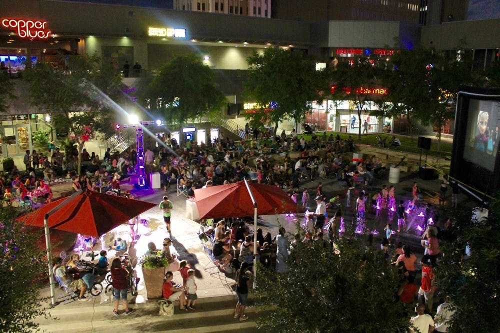 People watch movies as part of 'City Lights Movie Nights' at CityScape in downtown Phoenix in July 2015.