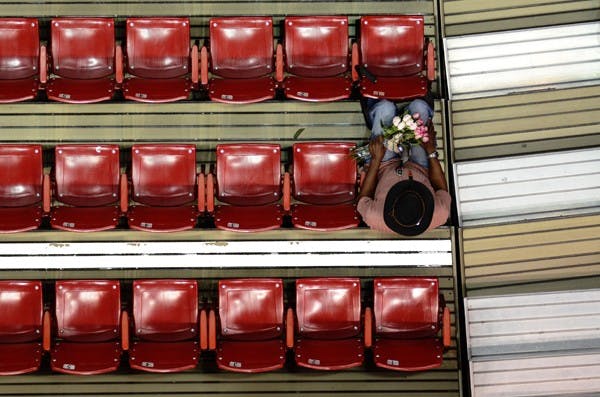 David Owens sits after handing out carnations at the women's basketball game versus Dayton on Sunday. "It's just my thing," Owens, who enjoys handing out flowers to young children and older women said. "For every smile I give, I get at least five back." (Photo by Aaron Lavinsky)