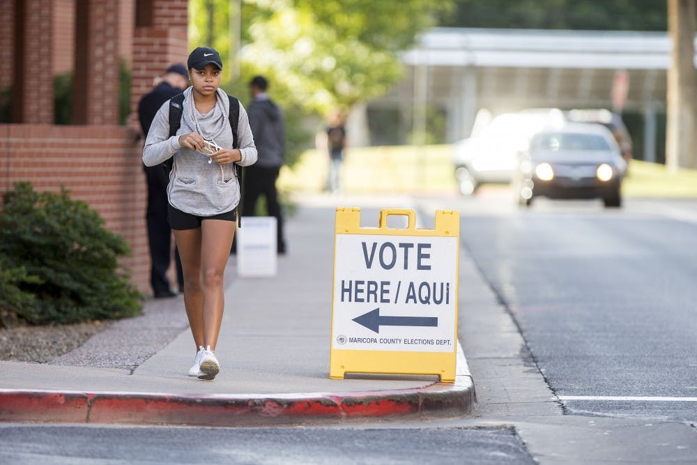 Students and cars pass by signs advertising the polling location in the Sun Devil Fitness Complex on the ASU Tempe campus on Tuesday, Nov. 8, 2016. Parking in the adjacent Apache structure is free for voters for up to one hour.