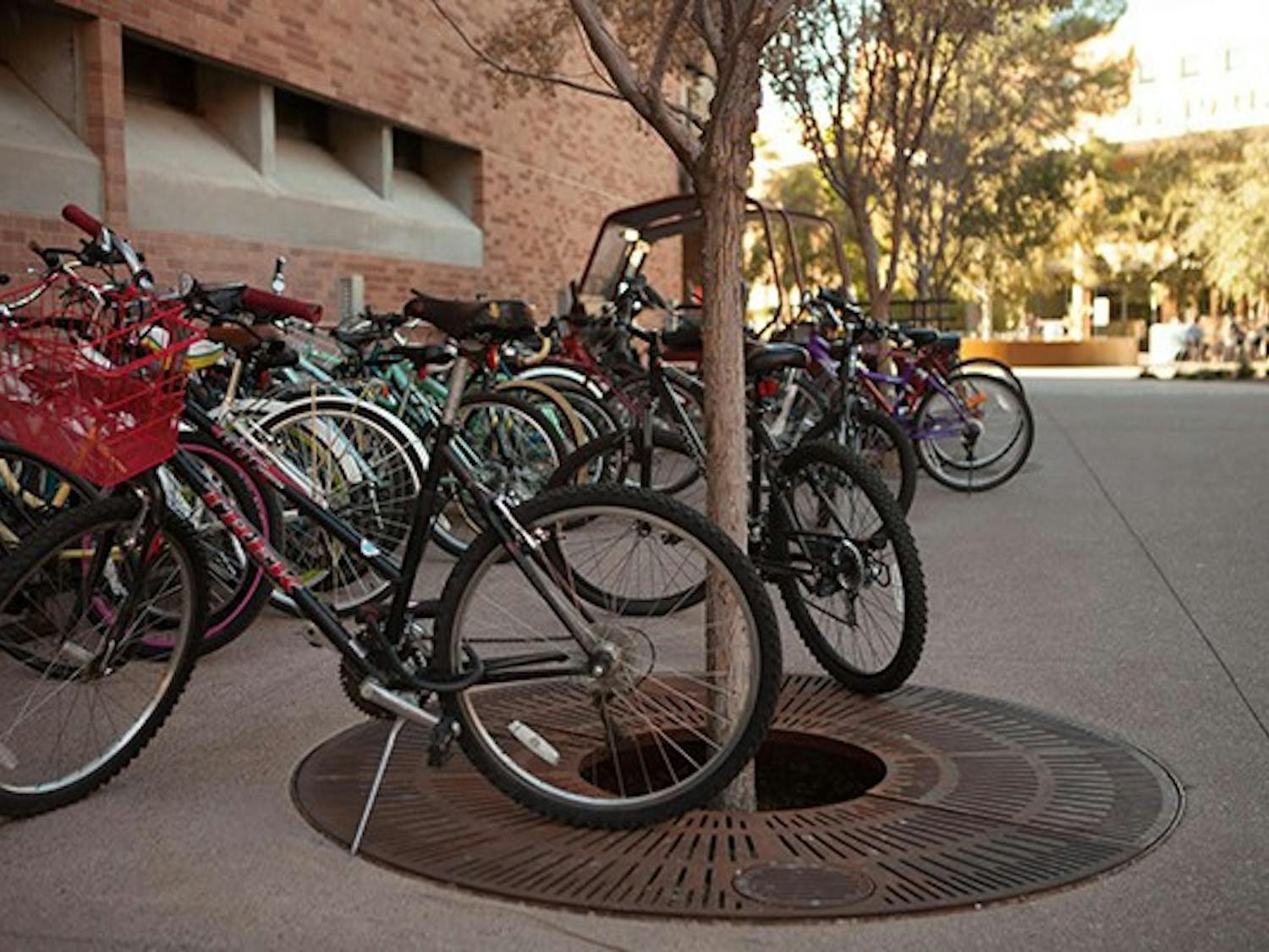 Bikes along the W.P. Carey building are locked onto itself or each other due to the insufficiency of bike racks in ASU. ASU was recently named one of the most bike-friendly campuses across the nation. However, Very often students can't find a bike rack and have to lock their bikes to the trees and fences. (Photo by Ryan Liu)
