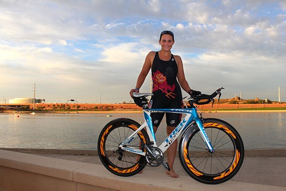 Marketing and supply chain senior Betsy Donahue poses with her bike at Tempe Town Lake two days prior to the IRONMAN race. (Photo by Ksenia Maryasova)
